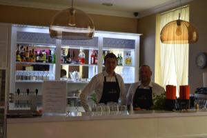 two men standing behind the counter of a bar at Pensjonat Nowy Młyn in Kostrzyn nad Odrą