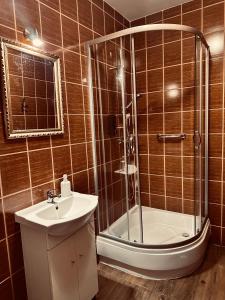 a bathroom with a shower and a sink and a tub at Pensjonat Nowy Młyn in Kostrzyn nad Odrą +14 photos