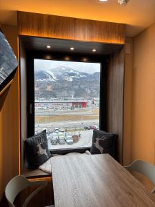 a dining room with a table and a large window at CUBE Alpine Stay in Bürs