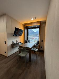 a dining room with a table and chairs and a window at CUBE Alpine Stay in Bürs