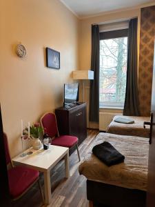 a hotel room with a bed and a table and chairs at Pensjonat Nowy Młyn in Kostrzyn nad Odrą