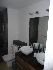 a bathroom with two sinks and a toilet and a mirror at Swiss Nest Travel in Roches Noires