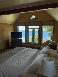 a bedroom with a large bed with a view of the ocean at Casa Ayacara in Frutillar
