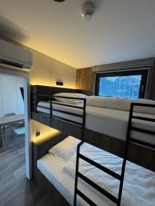 a room with three bunk beds with a window at CUBE Alpine Stay in Bürs