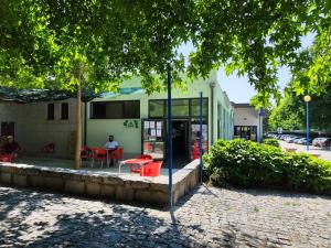 a person sitting at a table in front of a building at A Casa dos Avós in Cativelos