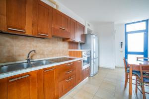 a kitchen with wooden cabinets and a sink and a table at Residence Il Sole in Porto Corsini