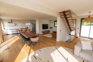 a kitchen and living room with a table and chairs at Superbe Maison 4ch proche de la mer avec piscine in Bénerville-sur-Mer