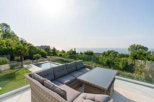 a living room with a couch and a table on a balcony at Superbe Maison 4ch proche de la mer avec piscine in Bénerville-sur-Mer