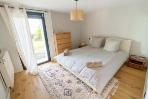 a bedroom with a large white bed and a window at Superbe Maison 4ch proche de la mer avec piscine in Bénerville-sur-Mer +16 photos