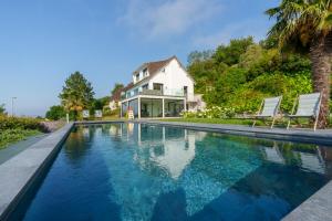 a house with a swimming pool in front of a house at Superbe Maison 4ch proche de la mer avec piscine in Bénerville-sur-Mer