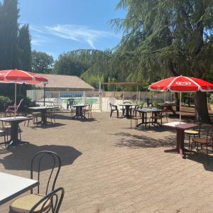 a group of tables and chairs with umbrellas at Camping le Faucon d'or in Montricoux