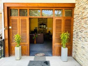 an open door with two potted plants in front of it at NAT City Ella in Ella