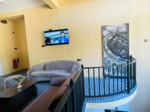 a living room with a couch and a tv on the wall at NAT City Ella in Ella