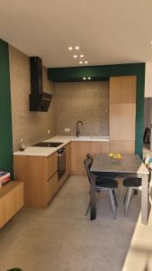 a kitchen with a table and some chairs and a stove at Gjiri Lalzit Sunset Bliss San Pietro Premium in Draç