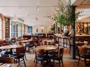 a restaurant with tables and chairs and a bar at Old Bank Hotel in Oxford