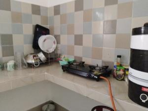 a kitchen counter with a stove and a blender at Pranalay HS Warm and Cozy in Tezpur