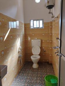 a bathroom with a toilet and a sink at Pranalay HS Warm and Cozy in Tezpur +14 photos