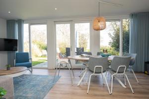 a dining room and living room with a table and chairs at Het Mienterbos in De Koog +16 photos