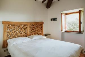 a bedroom with a large white bed with a window at Il Paliarete in Orvieto