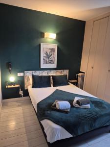 a bedroom with a large bed with two towels on it at Hôtel Saint James in Biarritz