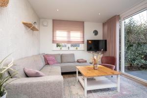 a living room with a couch and a table at Het Mienterbos in De Koog