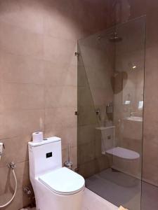 a bathroom with a toilet and a glass shower at Zanziluxe Residences in Zanzibar City