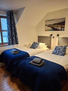 a bedroom with two beds with blue blankets at Ulster Cottages 4 miles From Portrush Bushmills Coleraine and Ballymoney in Bushmills
