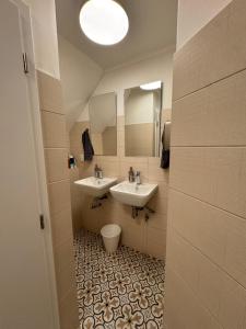 a bathroom with two sinks and a toilet at Hostel John Galt in Brno +20 photos