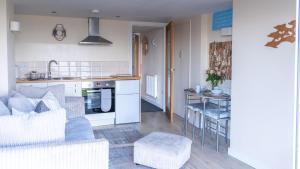 a kitchen and living room with a couch and a table at Superb Cintra Beachside Apartments in Llandudno +77 photos