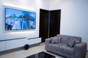 a living room with a tv and a chair at Zanziluxe Residences in Zanzibar City