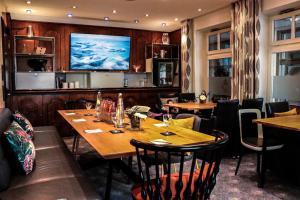 a restaurant with tables and chairs and a flat screen tv at Hotel König Ludwig II in Garching bei München