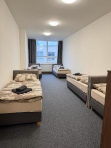 a room with three beds and a window at Penzion BETA in Třebíč