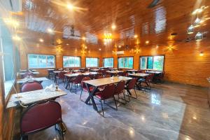 a restaurant with tables and chairs in a room at The Crystal Woods Resort in Mendarda