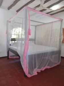 a bedroom with a bed covered in mosquito nets at Sofia House - Beach Paradise with Kite, Dive and more in Watamu