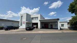 a building with a car parked in front of it at J&R Gästezimmer Kassel in Niestetal