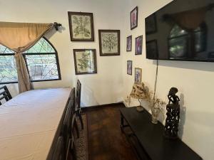 a bedroom with a bed and a tv on the wall at Sofia House - Beach Paradise with Kite, Dive and more in Watamu