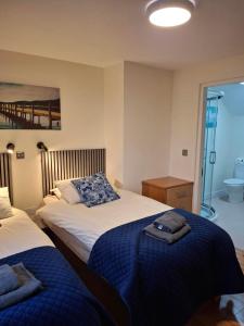 a bedroom with two beds and a bathroom at Outside of Coleraine Cottage in Coleraine
