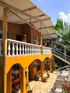 a yellow building with a balcony and a staircase at Hostal Casa LUCY in Yumbo