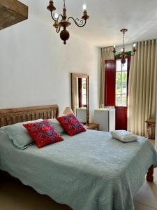 a bedroom with a bed with two pillows on it at Solar de Amelia in Tiradentes