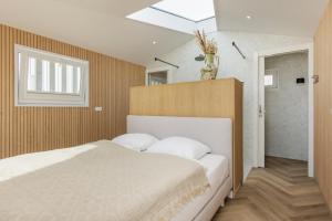 a bedroom with a large bed and a skylight at Lua Beach House in Zandvoort