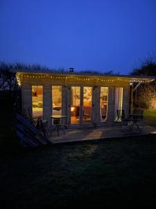 a house with a deck at night with lights at Yellowhammer Hut at Carr House Farm in Cayton