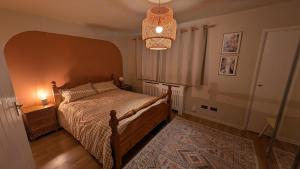 a bedroom with a bed and a chandelier at 70's Inspired 1 Bed flat in Knebworth