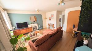 a living room with a couch and a flat screen tv at 70's Inspired 1 Bed flat in Knebworth