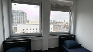 a room with two windows with a couch in front at Hotelikum zentreal Bequem in Heilbronn