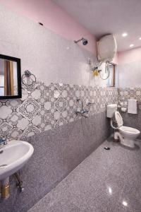 a bathroom with a sink and a toilet at Hotel Crown Patliputra in Patna