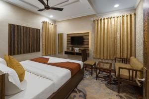 a hotel room with a bed and a tv at Hotel Crown Patliputra in Patna