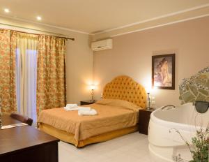 a bedroom with a bed and a bath tub at Hotel Athina in Kato Loutraki +30 photos