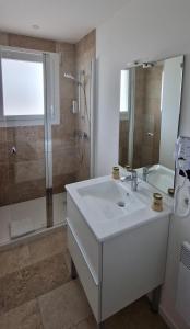 a white bathroom with a sink and a shower at Cit'Hôtel Le Quai 9 in Challans +63 photos