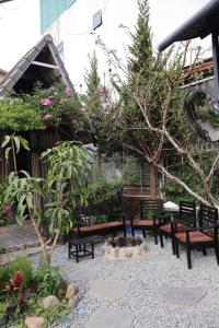 a garden with benches and a fire pit with flowers at Trạm Chill Homestay in Khu Chi Lăng