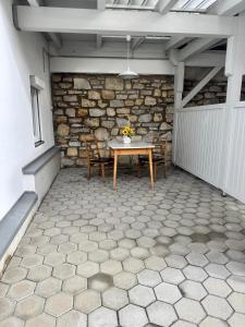 a patio with a table and chairs and a stone wall at Haus Anna in Köttwein +3 photos